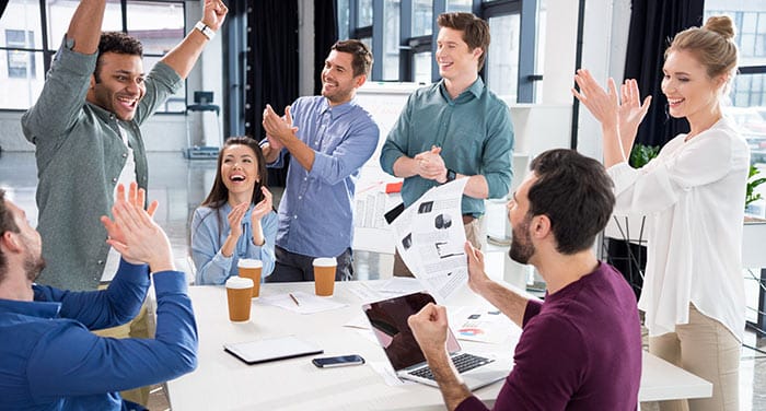 Une équipe soudée félicitant un de ses membres.
